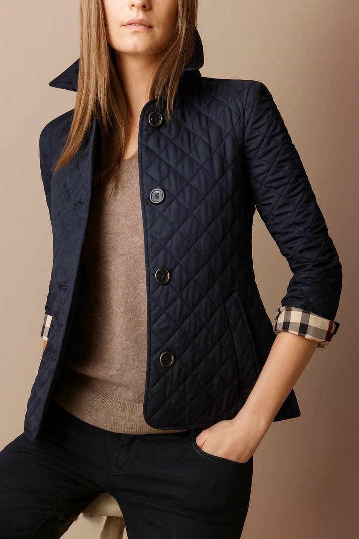 Woman wearing navy quilted jacket with hand in pocket